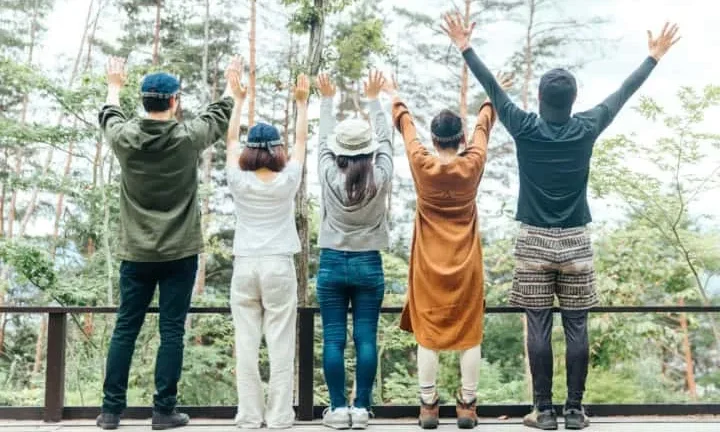 Sepasang kekasih sedang menikmati api unggun di depan tenda glamping mereka.