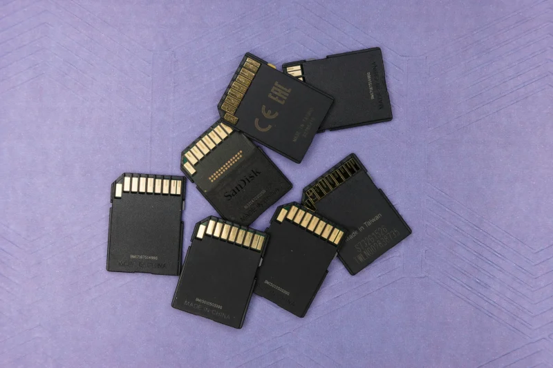 Tangan seseorang sedang memasukkan kartu SIM ke dalam smartphone.