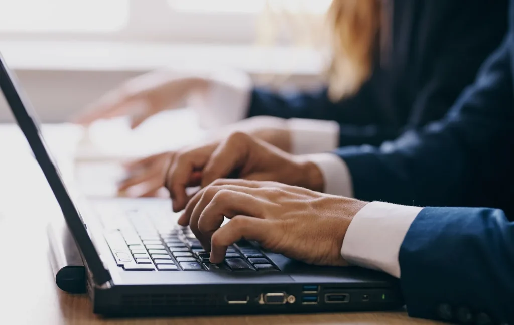 Seseorang sedang mengetik email bisnis di laptop.
