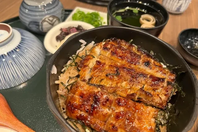 Hidangan sukiyaki yang sedang dimasak di dalam panci panas.